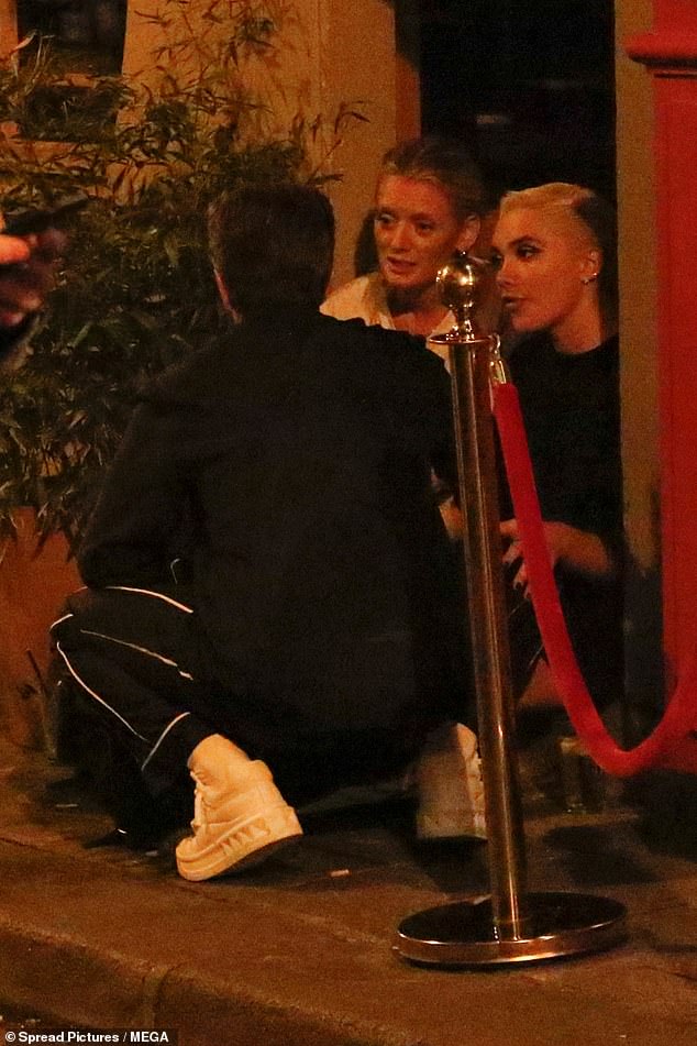 Cop-a-squat: Florence Pugh proved she's not afraid to do it in a slum as she sat on the streets of Paris enjoying a chat with her co-star Andrew Garfield