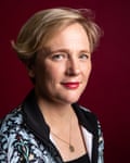 MP Stella Creasy, with short slicked-back hair and a locket on a chain, smiles slightly