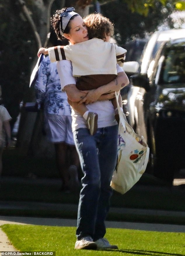 Cute: Halsey was relaxed as she stepped out with her son Ender, two, in Los Angeles on Friday.  She wore a white t-shirt with straight leg jeans and white sneakers as she lovingly wore the t-shirt while carrying a shopping bag