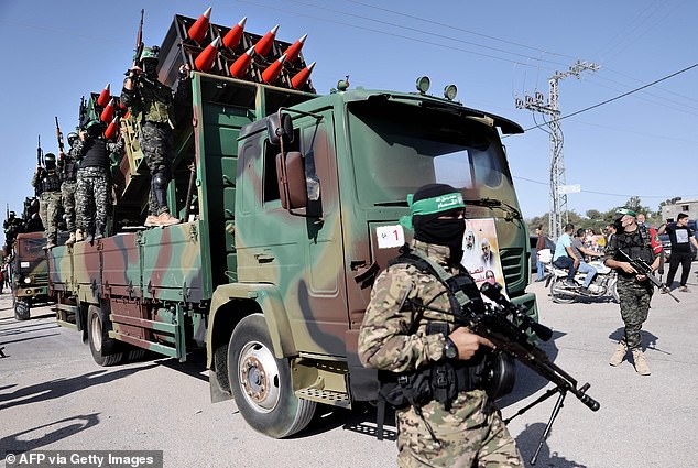 Members of the Ezz-Al Din Al-Qassam Brigades, the armed wing of the Hamas movement, parade on a truck carrying rockets on a street in Khan Yunis, southern Gaza Strip