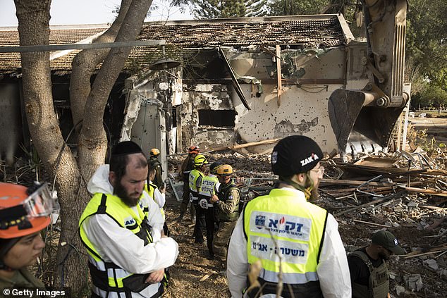 Members of army rescue and ZAKA crews search for bodies after Hamas attack on Kibbutz Be'eri