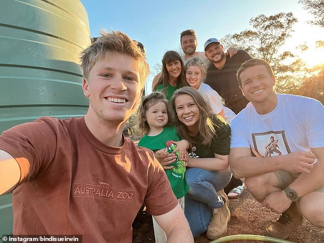 A heartbreaking detail in Bindi Irwin's recent family picture was revealed as the conservationist clan gathered for a group photo.  Pictured (from back): Australia Zoo Managing Director Luke Revley, his partner Mitch, Terry Irwin, Rory Bucky, Grace Warrior, Bindi Irwin, Chandler Powell and Robert Irwin