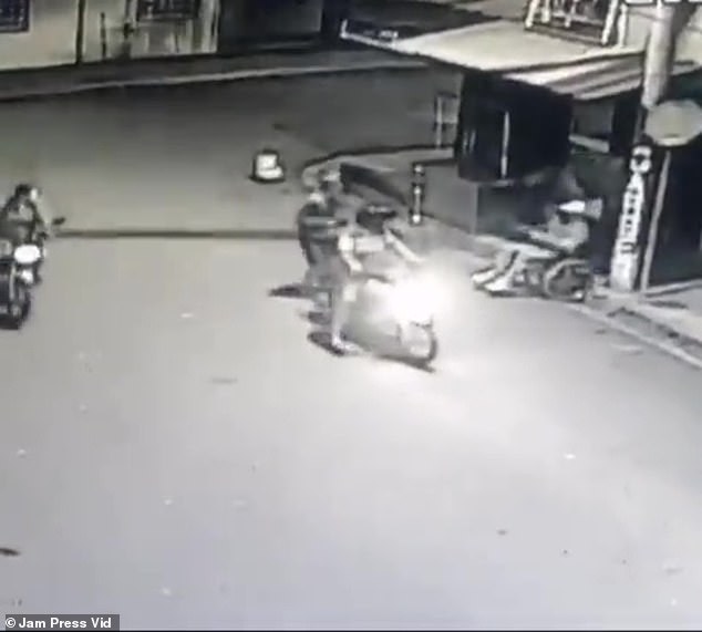 In the clip, he is seen drawing a gun as two men arrive on a motorcycle and fire shots in his direction