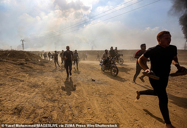 Palestinians cross the Gaza-Israel border fence in Khan Yunis, in the southern Gaza Strip in a surprise incursion into southern Israel on Saturday