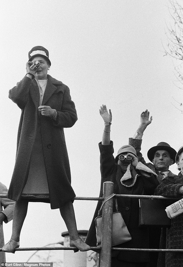 Westerners look over the wall while it is still low enough to look at Berlin, Germany, 1961