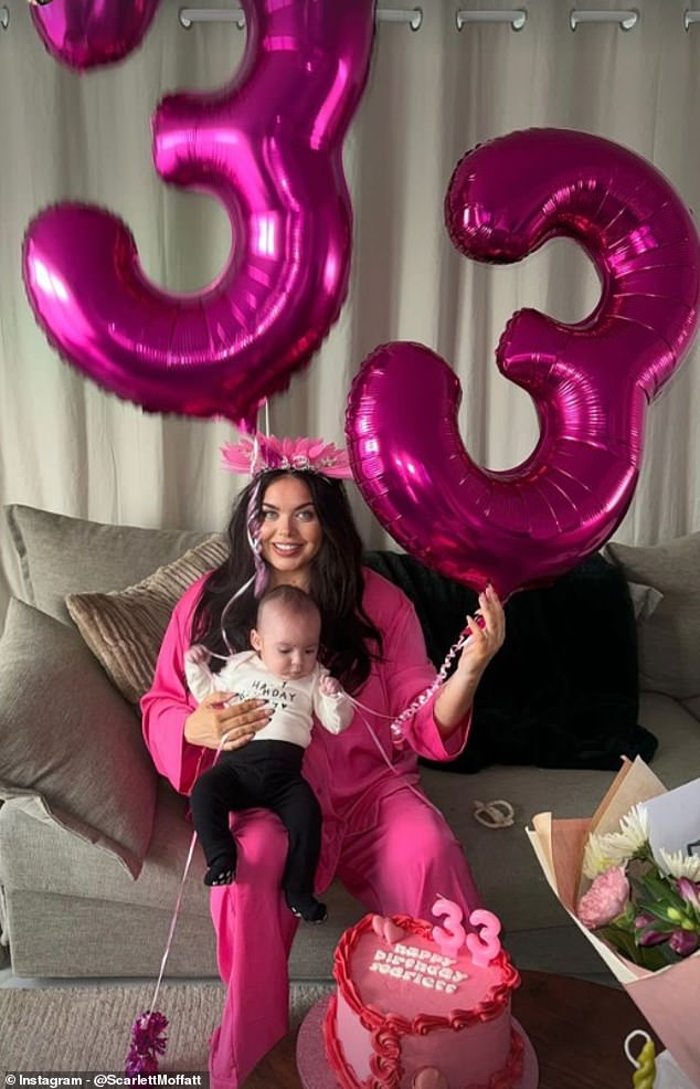 Family fun: The mother beamed at the camera for the first time as she held a huge metallic pink "33" balloons while holding baby Jude on her lap on the sofa