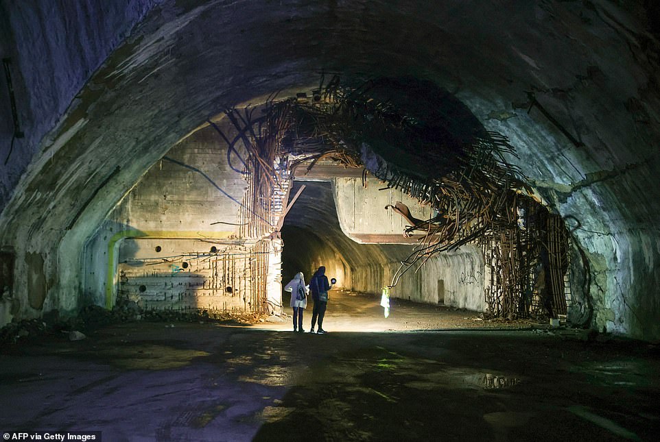 The Zeljava underground air base, carved into the side of a mountain on the border of Croatia and Bosnia and Herzegovina, was once one of Europe's largest military complexes (visitors are pictured exploring the base)