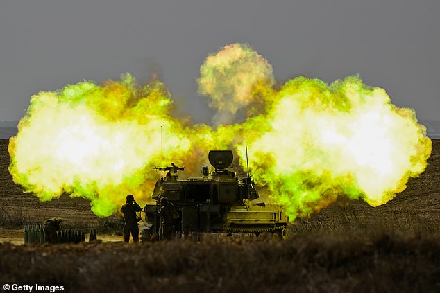 An IDF soldier covers his ears as a shell is fired into Gaza on Wednesday