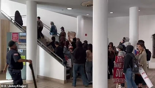 A pro-Palestinian mob is seen storming past a guard on Wednesday, shouting: 'Free, free Palestine'