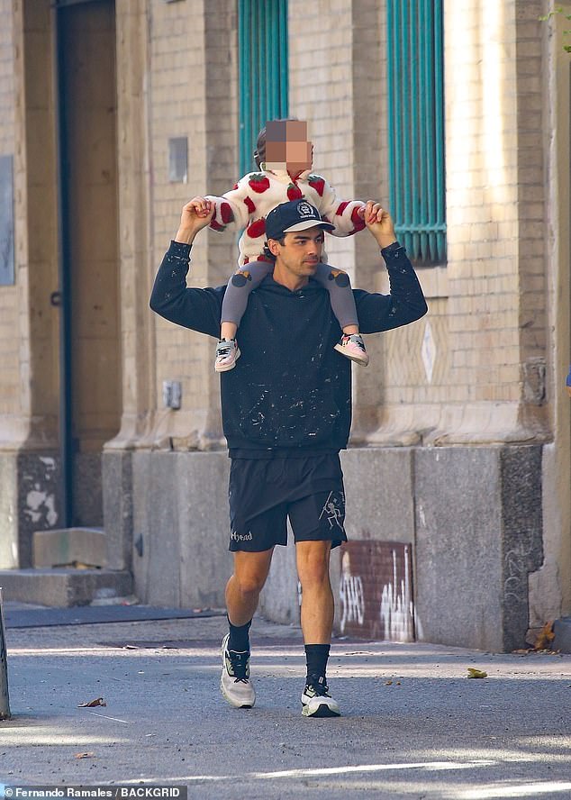 Doting dad: Joe Jonas, 34, was ever the doting dad on Wednesday as he was spotted taking a walk with his two daughters, Willa, three, and Delphine, one, in New York City