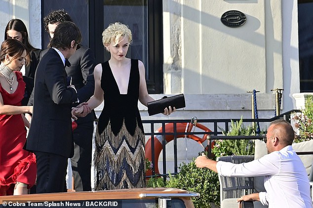 Gorgeous: Julia Garner, 29, stunned in a glitzy plunging dress as she arrived with husband Mark Foster, 39, at Anya Taylor-Joy and Malcolm McRae's wedding in Italy this weekend