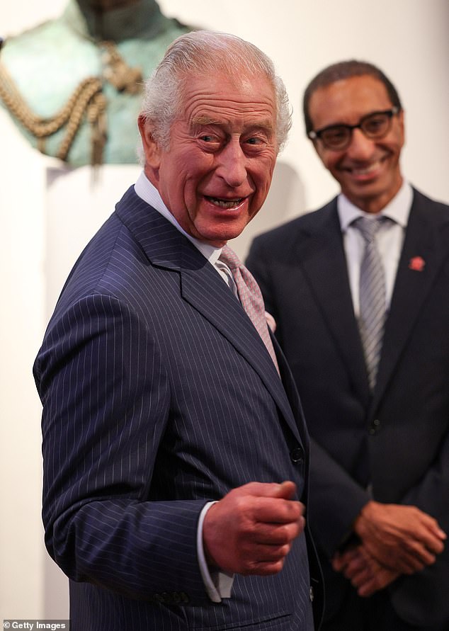 King Charles was seen in good spirits today as he attended an elite reception for African business leaders in London (Photo: King Charles stands by a statue of himself as he welcomes guests to the reception)