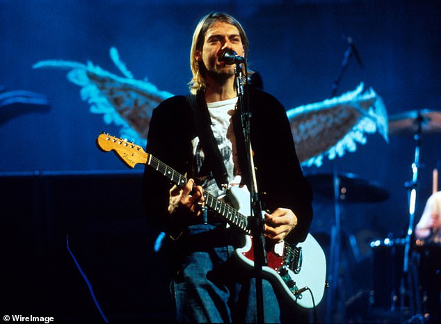 GUITAR HERO: Cobain with his Skystang in 1990. The guitar has a striking yellow V on the pickguard