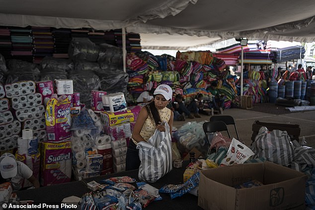 A volunteer receives humanitarian aid at a collection center in the aftermath of Hurricane Otis in Acapulco, where 43 of the 48 deaths have been reported