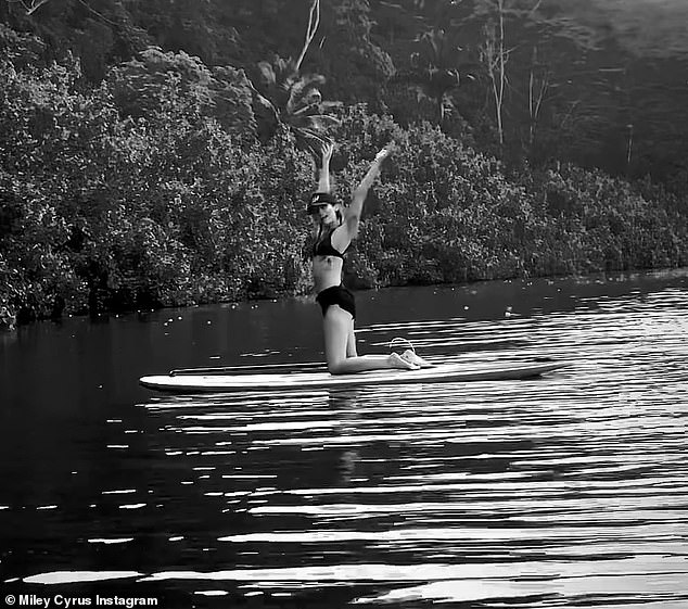 Get away: Miley Cyrus took to Instagram on Sunday to share photos of herself doing yoga on a paddleboard