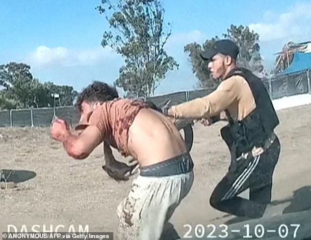 An armed Palestinian militant leads a man during the Supernova music festival