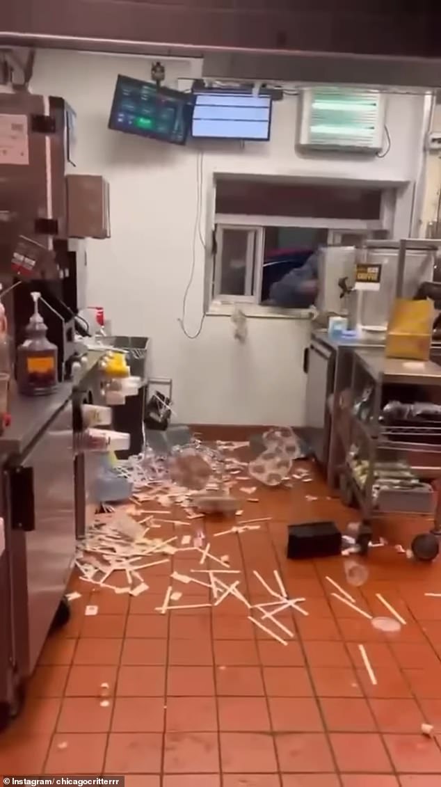Once the customers have received their money, a man takes his drink and violently throws it across the restaurant towards the employee who is filming