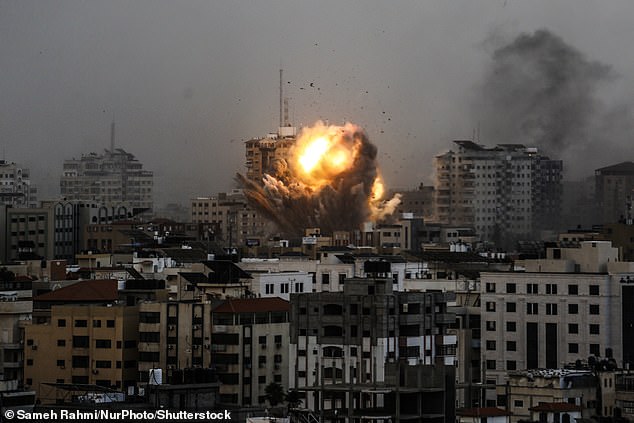 Smoke rises and a fireball over a building in Gaza City on October 9, 2023