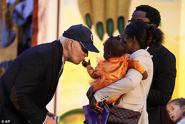 President Joe Biden kisses a little girl dressed as a pumpkin