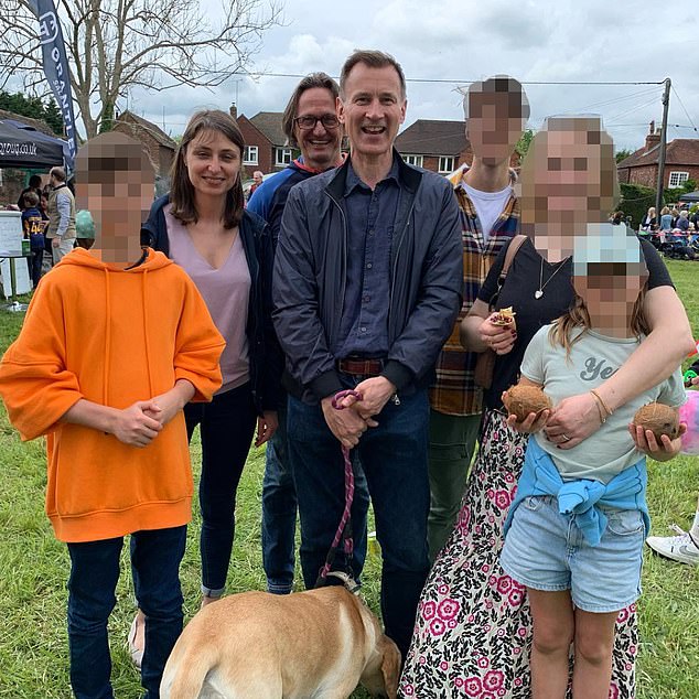 Jeremy Hunt (center) tweeted a photo (top) of Mr. Overli, his family and Ms. Polonchuk at a local event last year before the couple got together