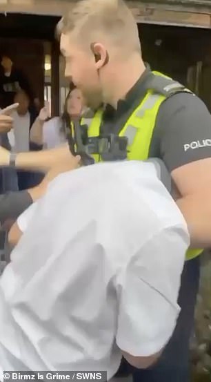 Officers were called to a house in Bromford, Birmingham, at around 5.20pm yesterday, where someone was filmed holding the child in a headlock as onlookers repeatedly shouted 'Get off him!'