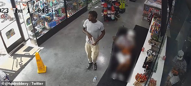 The suspect casually walks past the disabled victim and checks the wallet he opened at the cash register