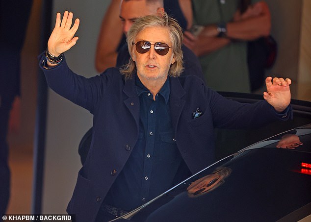 The British rocker was dressed in a blue button-up shirt which he paired with a navy blue jacket