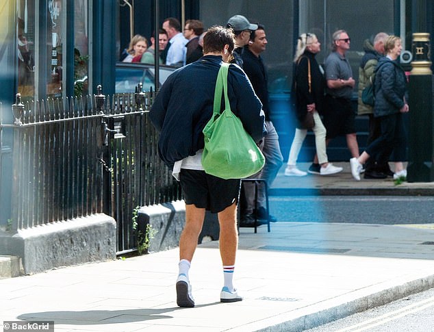 Casual: The former One Direction star, 29, opted for a navy blue quilted jacket and black shorts for a day out