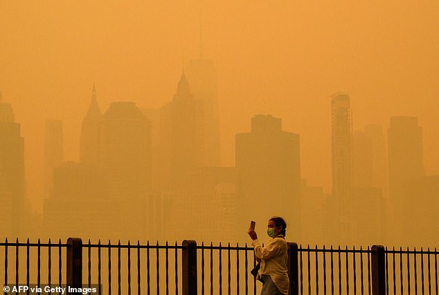 New York City was shrouded in smoke this summer due to Canadian wildfires.  Pictured above: A person wearing a face mask in the haze that blanketed New York in June