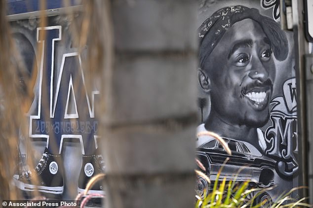 Part of a mural by artist sloe_motions depicting Tupac Shakur is seen on the side of Speedy Auto Tint on Friday, September 29, 2023 in Bellflower, California.  (AP Photo/Chris Pizzello)