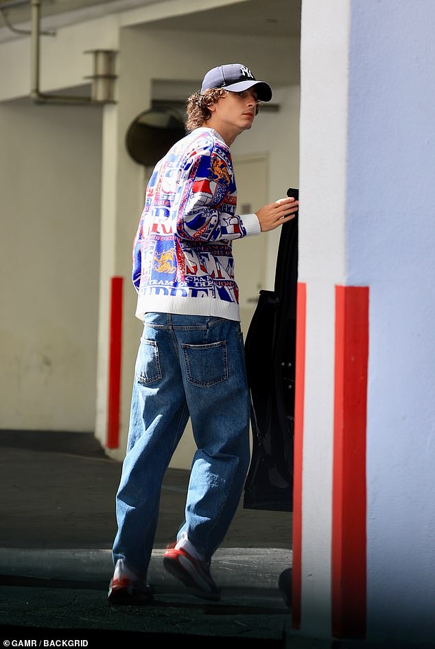 Cool guy: He completed the trendy outfit with distressed jeans and multi-colored Nike sneakers