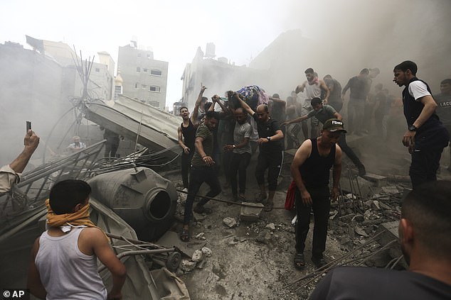 FILE - Palestinians remove a body from the rubble of a building after an Israeli airstrike in the Jebaliya refugee camp, Gaza Strip, Monday, October 9, 2023