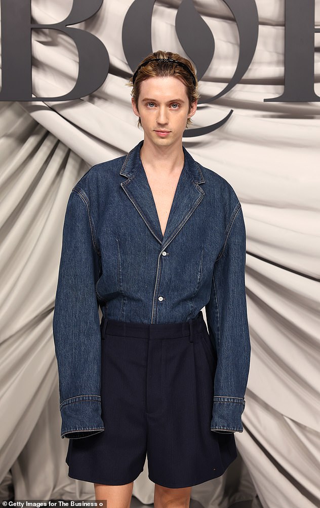 The Australian singer showed off his unique fashion style in an oversized denim shirt paired with black shorts, long socks and matching dress shoes