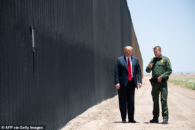 Former President Donald Trump says he is owed an apology after Biden's hypocrisy in repeatedly rejecting his construction of the physical southern border barriers.  Trump speaks with U.S. Border Patrol Chief Rodney Scott (R) as they participate in a ceremony commemorating the 200th mile of border wall with Mexico in San Luis, Arizona, June 23, 2020