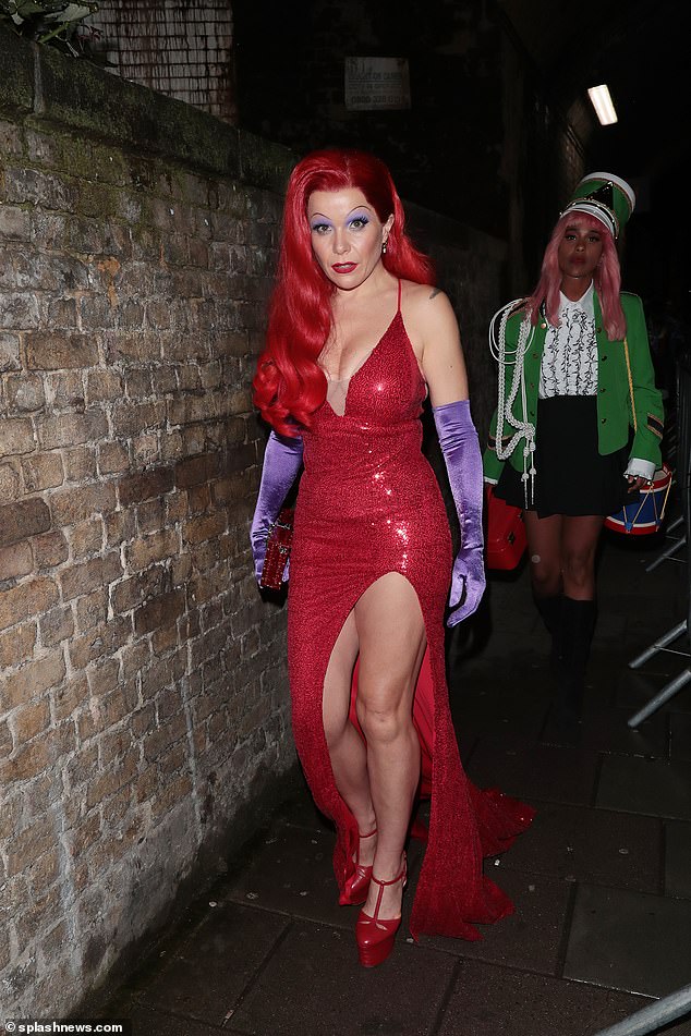 Leggy: She added Jessica's bright red hair and dramatic makeup, while also wearing a pair of purple silk gloves and a pair of sky-high platform heels