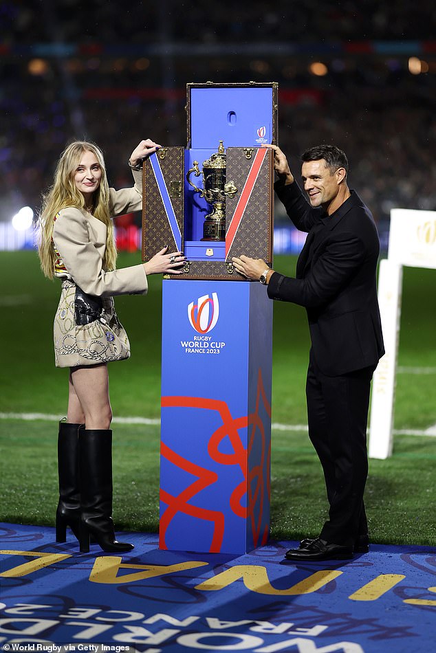 Busy: The new couple enjoyed a romantic smooch in public before saying goodbye to chauffeured cars and later reuniting at the Stade de France where Sophie unveiled the trophy (pictured with Dan Carter)