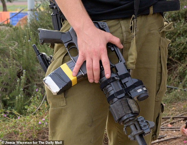 Uria Goldman is armed with an assault rifle (pictured) and patrols the otherwise deserted California-style neighborhoods on a golf cart.  The back of his T-shirt features the words 'Volunteer Tactical Team'