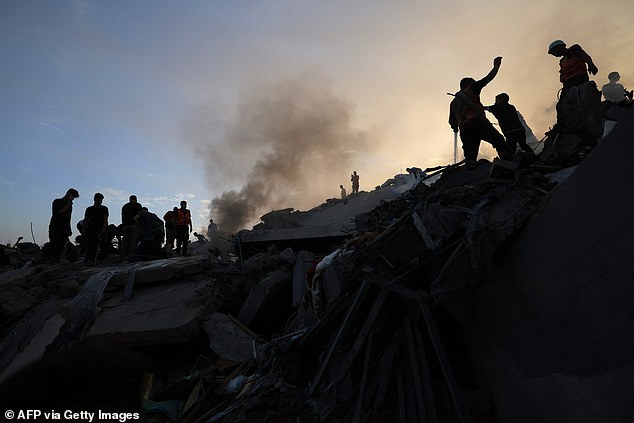 Palestinians search for survivors Tuesday in the rubble of a building in the Nuseirat refugee camp, in the central Gaza Strip