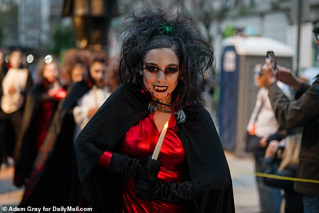 A partygoer cradles a candle as they participate in the many musical and dance aspects of the fristivities