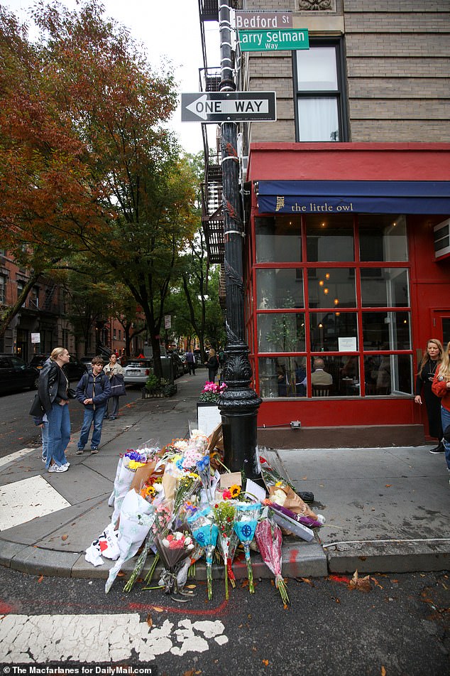 Much Missed: Dozens of mourners placed flowers, heartfelt notes and quotes from Perry's legendary character Chandler Bing outside the 'Friends' building in New York City's West Village