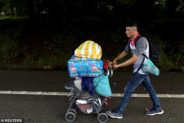 A migrant pushes a stroller as he walks along the road in Tapachula, Mexico, next to a caravan of about 5,000 people from Central America, Venezuela, Haiti and Cuba in an attempt to reach the U.S. border