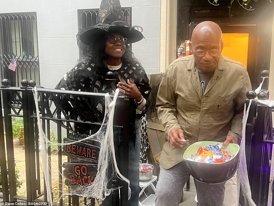 Handing out candy: The city closed a block in Manhattan to allow children to safely celebrate Halloween, which the couple happens to live on