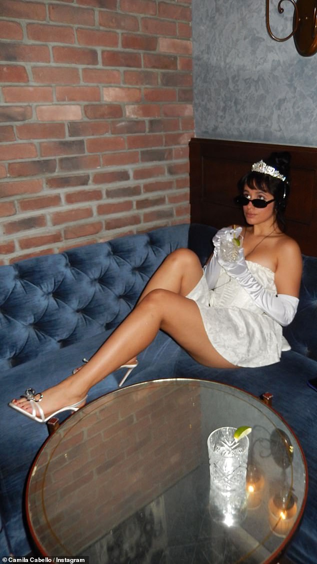 Legs for days: She showed off her fit legs in a glamorous yet casual photo, relaxing in a blue velvet booth during a break at the party