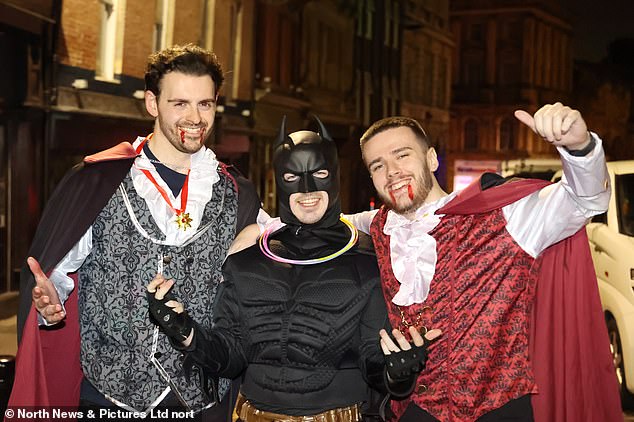 Two boys dressed as vampires posed with their friend in a Batman costume during a night out in Newcastle