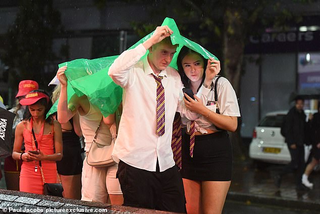 Two people tired to avoid the rain as they dressed up with a shirt and tie during a night out in Portsmouth