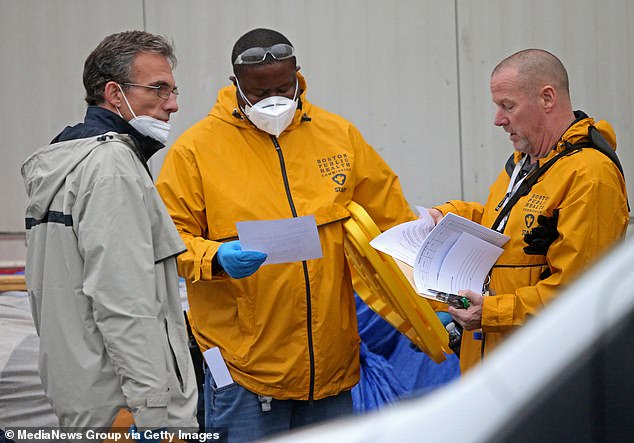 The area has been inhabited for years by tents and tarps housing people struggling with substance addiction.  Pictured: Boston Public Health workers in the Methadone Mile area on October 25