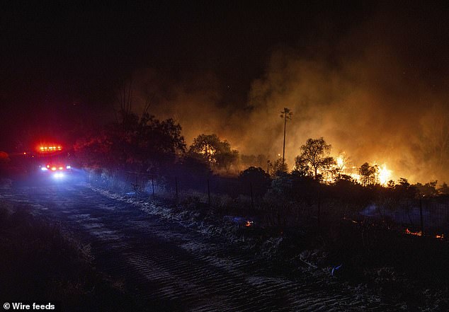 A fire truck approaches like a structure engulfed in flames