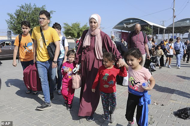 Relieved Palestinians cross to the Egyptian side of the Gaza Strip border crossing