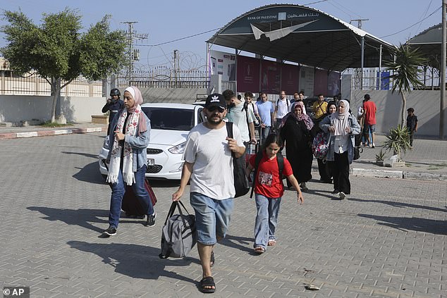 Palestinians with only a few possessions cross the Egyptian side of the border with the Gaza Strip