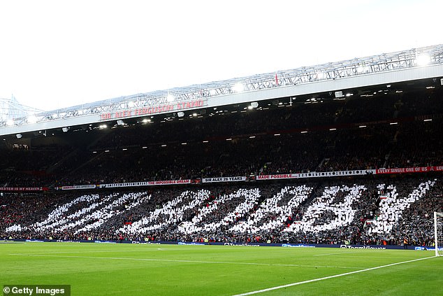 Fans hold up cards to create a mural in memory of Sir Bobby Charlton ahead of the Premier League match between Manchester United and Manchester City